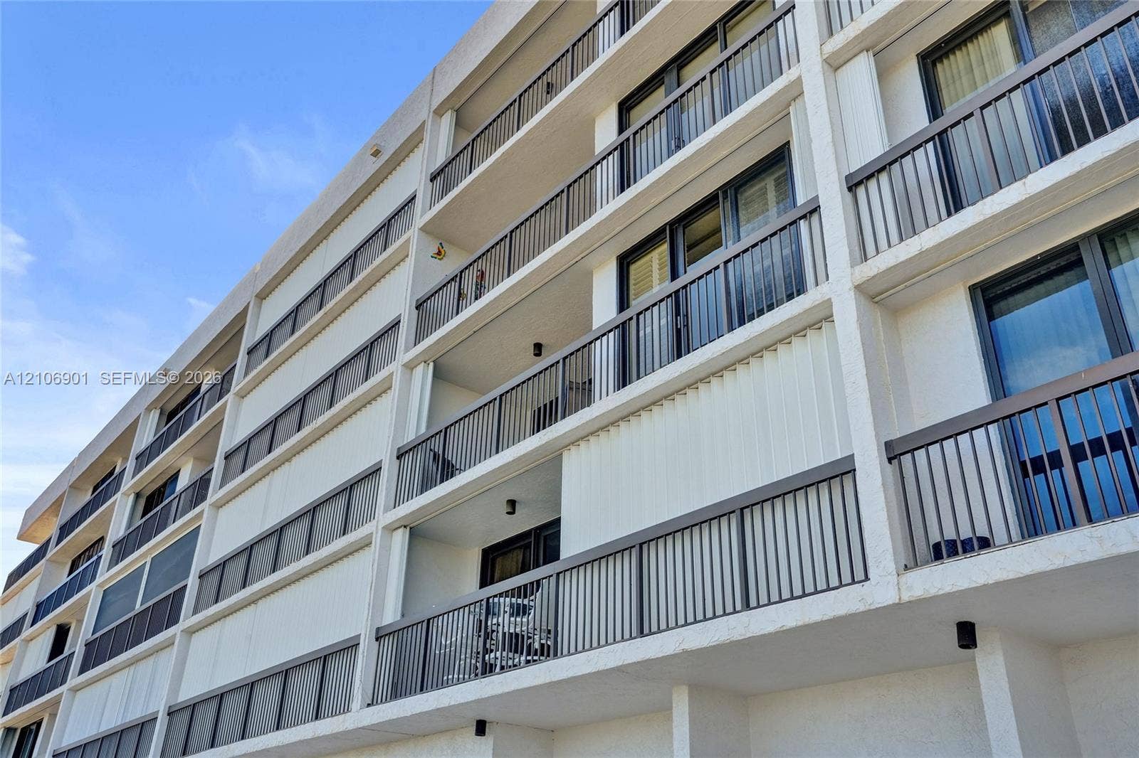 510 N Ocean Boulevard, #308, Pompano Beach, FL 33062 Multi-story residential exterior featuring stacked private balconies, vertical metal railings, and sliding glass door access