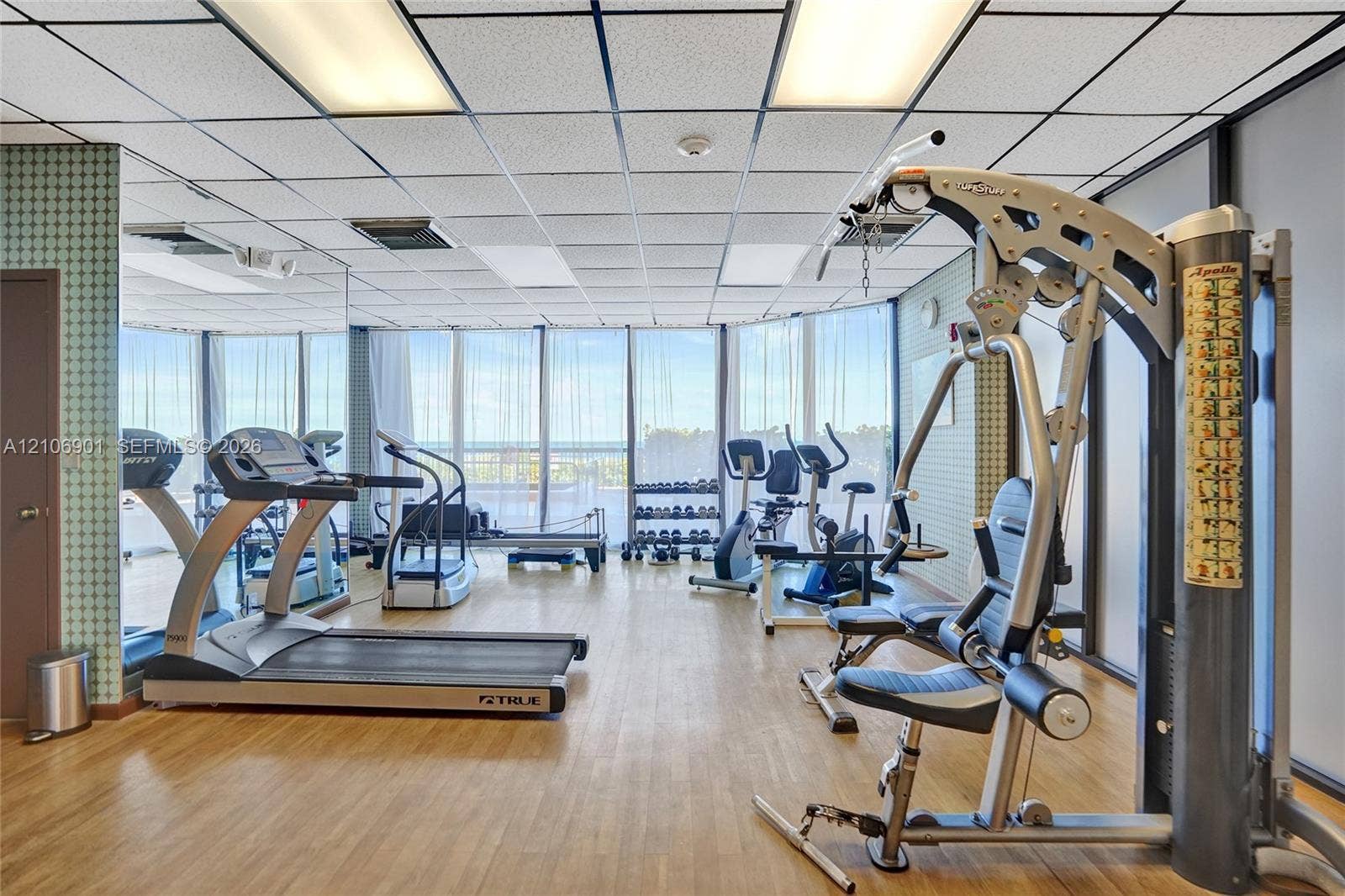 510 N Ocean Boulevard, #308, Pompano Beach, FL 33062 Fitness center featuring wood-finish flooring, floor-to-ceiling windows, and integrated wall-to-wall mirrors