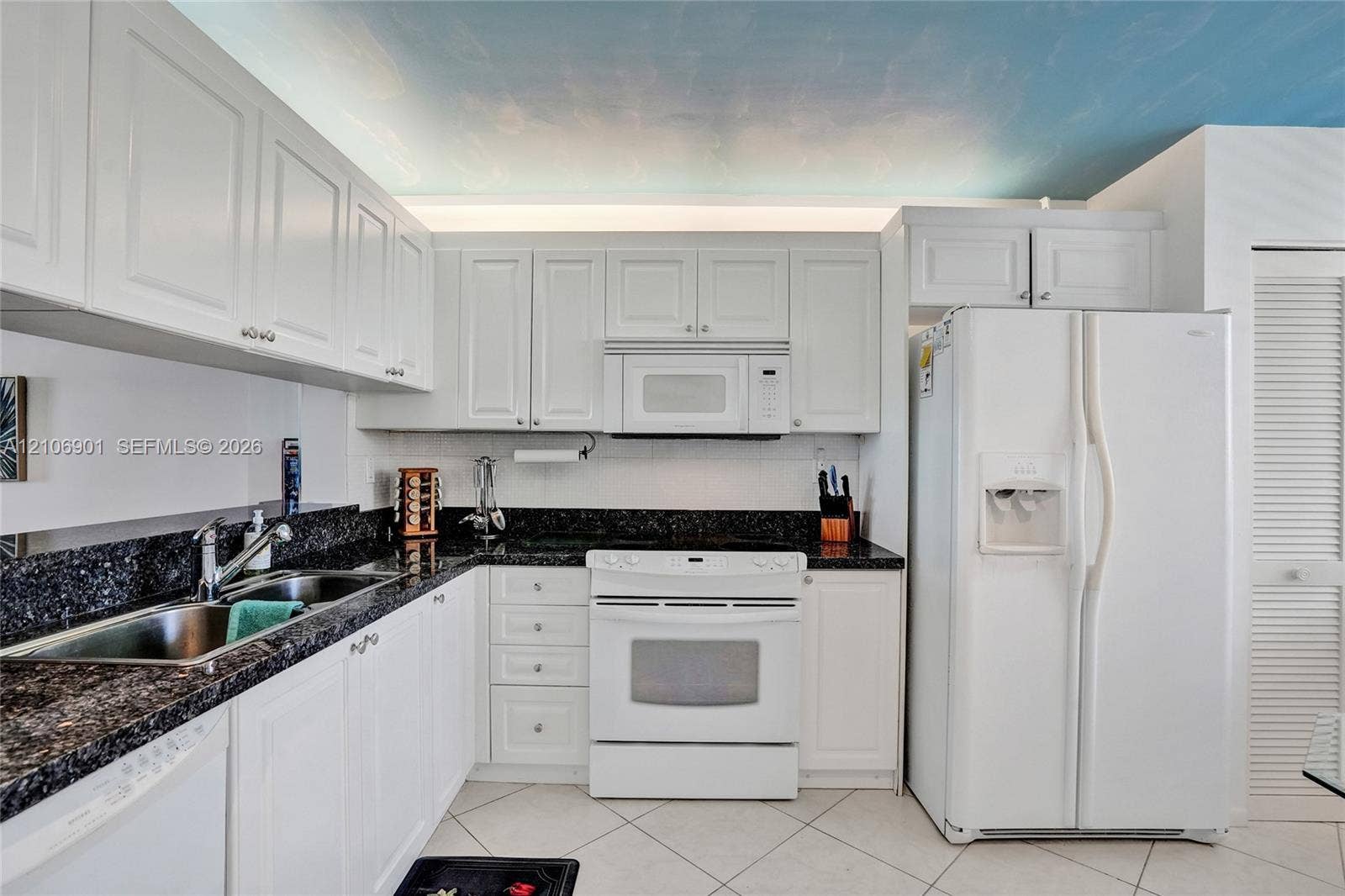 510 N Ocean Boulevard, #308, Pompano Beach, FL 33062 Kitchen featuring white cabinetry, dark stone-finish countertops, tile flooring, and integrated white appliances