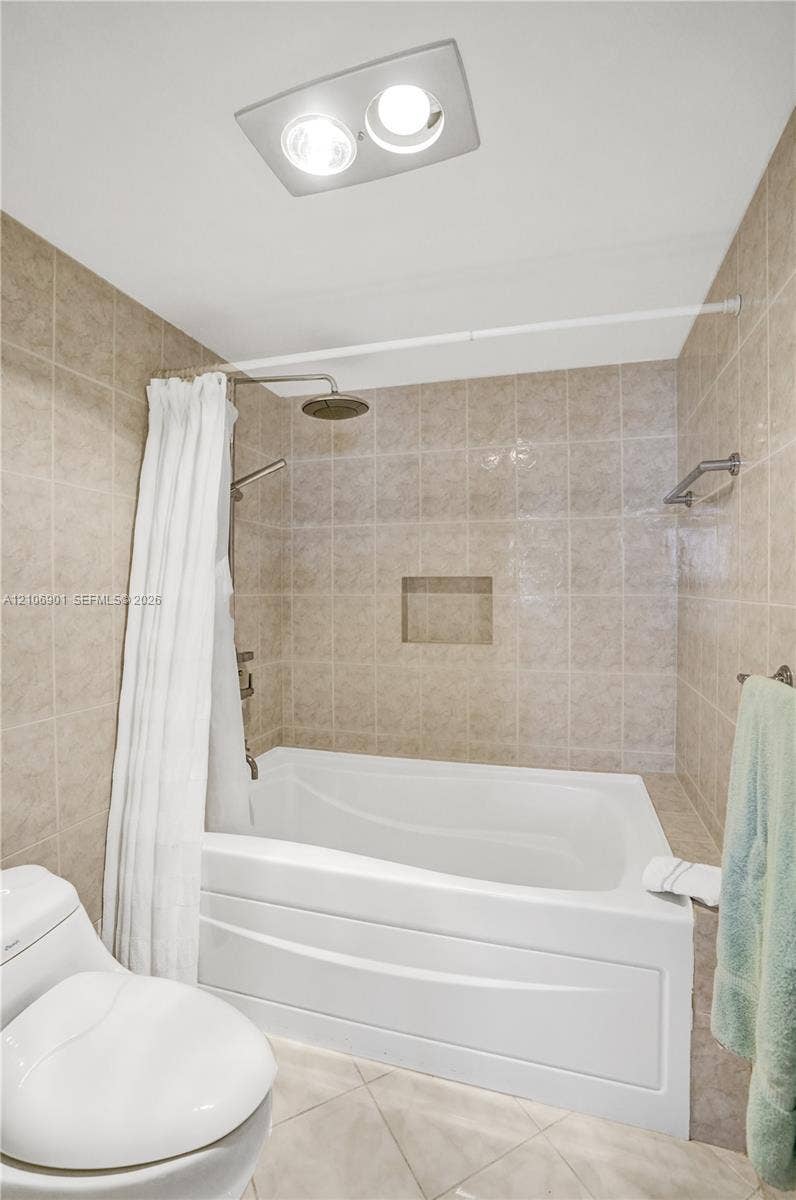 510 N Ocean Boulevard, #308, Pompano Beach, FL 33062 Bathtub with tile surround, built-in recessed wall niche, dual shower head system, and integrated ceiling lighting