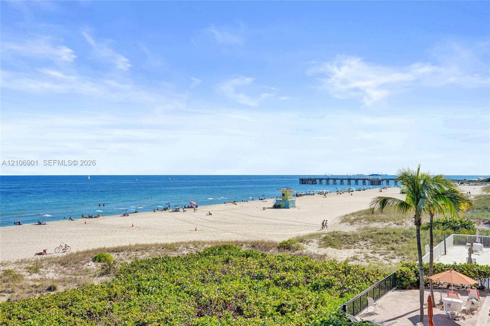 510 N Ocean Boulevard, #308, Pompano Beach, FL 33062 Private patio featuring paved flooring, metal railings, mature landscaping, and an expansive ocean backdrop