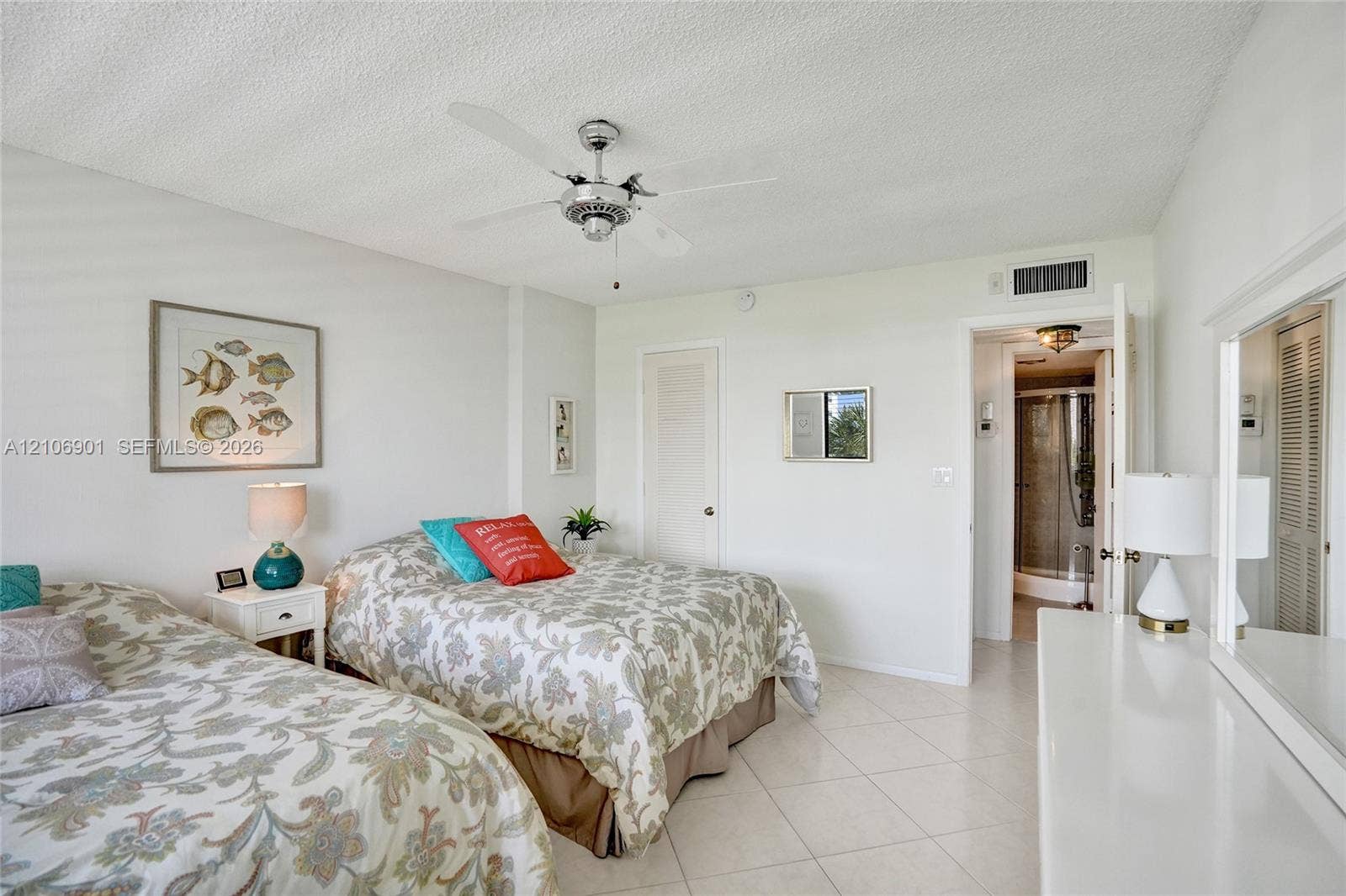 510 N Ocean Boulevard, #308, Pompano Beach, FL 33062 Neutral-toned room featuring large-format tile flooring, a central multi-blade ceiling fan, and a built-in closet with louvered doors