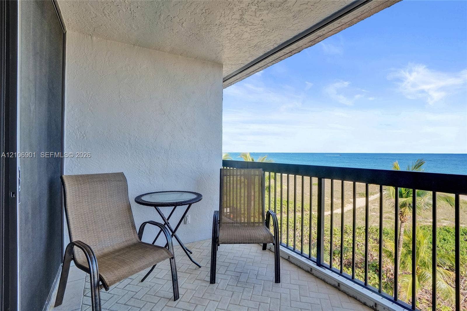 510 N Ocean Boulevard, #308, Pompano Beach, FL 33062 Covered balcony featuring herringbone-patterned tile flooring and a black metal railing overlooking the ocean