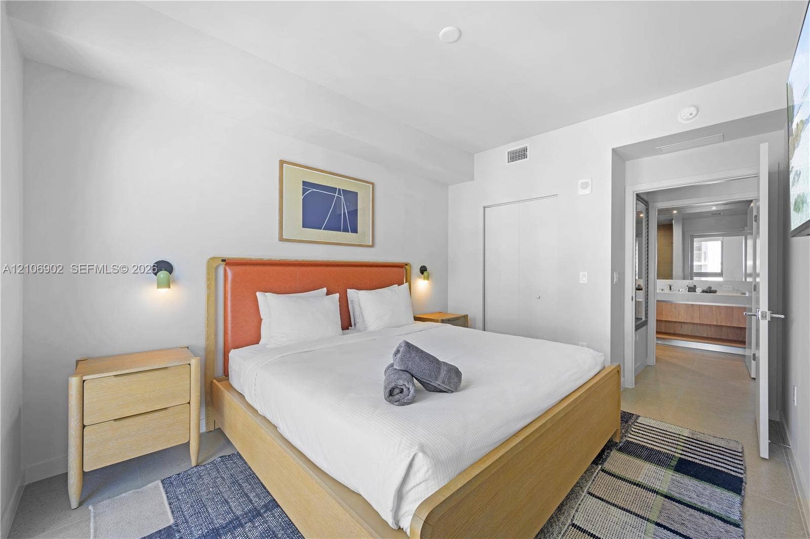 11 NE 6th Street, #1111, Miami, FL 33132 Neutral-toned room featuring a smooth finish, two wall-mounted accent sconces, and high-gloss interior doors