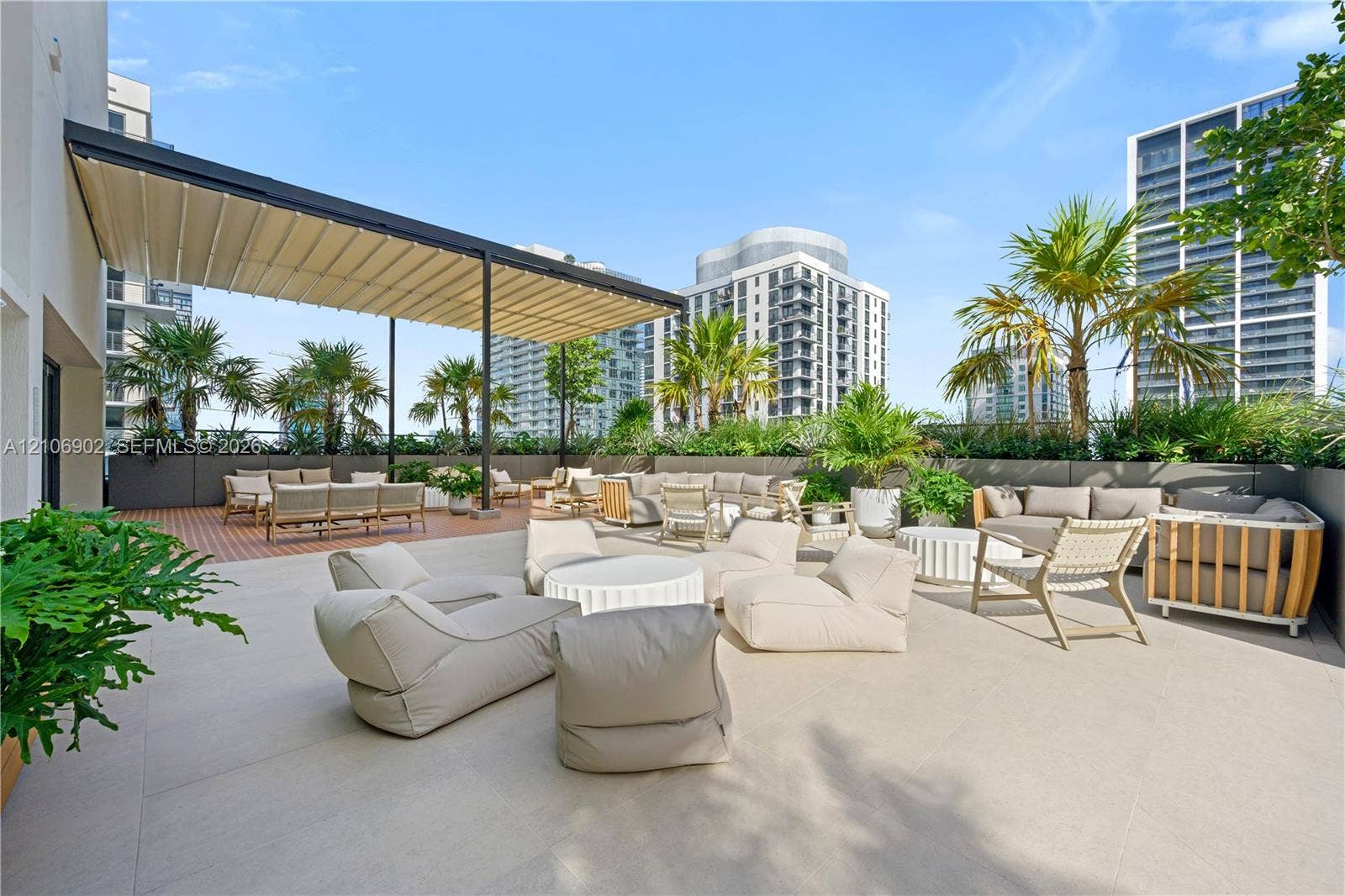 11 NE 6th Street, #1111, Miami, FL 33132 Expansive rooftop terrace featuring large-format tile flooring, a retractable shade canopy, and integrated perimeter planters