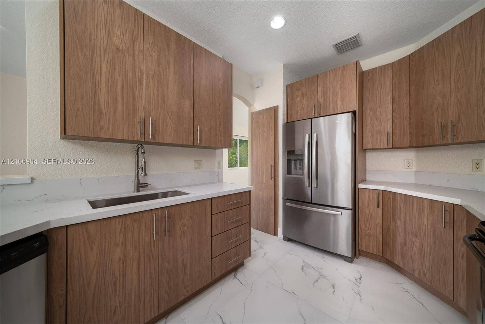 297 Conservation Drive, Weston, FL 33327 Kitchen featuring wood-finish cabinetry, quartz countertops, stainless steel appliances, and large-format tile flooring
