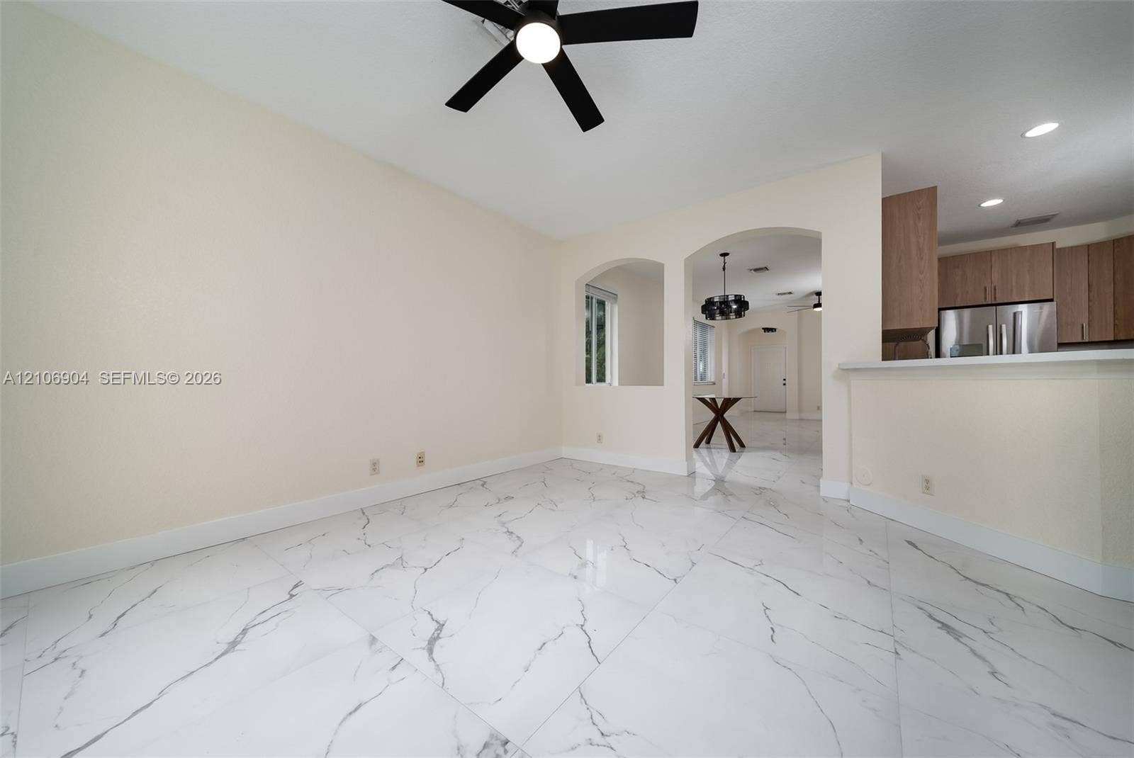 297 Conservation Drive, Weston, FL 33327 Large-format polished tile flooring featuring a veined pattern, recessed lighting, architectural arched cutouts, and a ceiling-mounted fan with integrated lighting