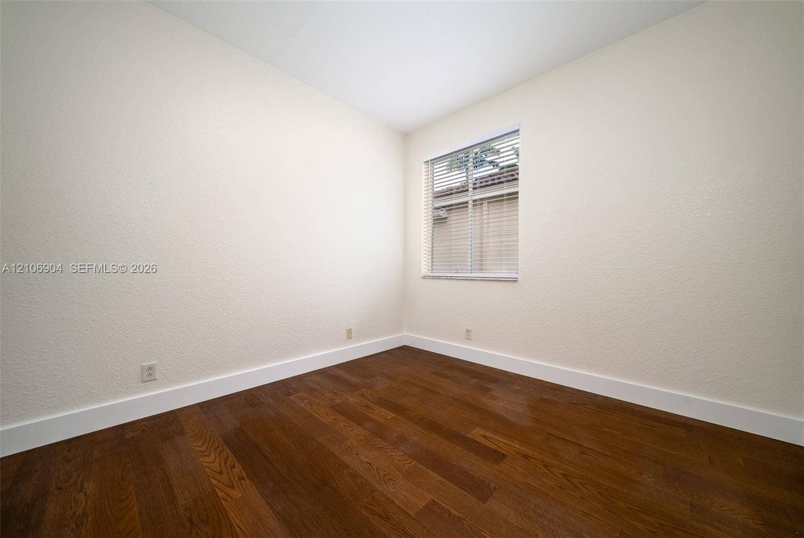 297 Conservation Drive, Weston, FL 33327 Interior room featuring wood-finish flooring, neutral wall tones, and a window with horizontal blinds