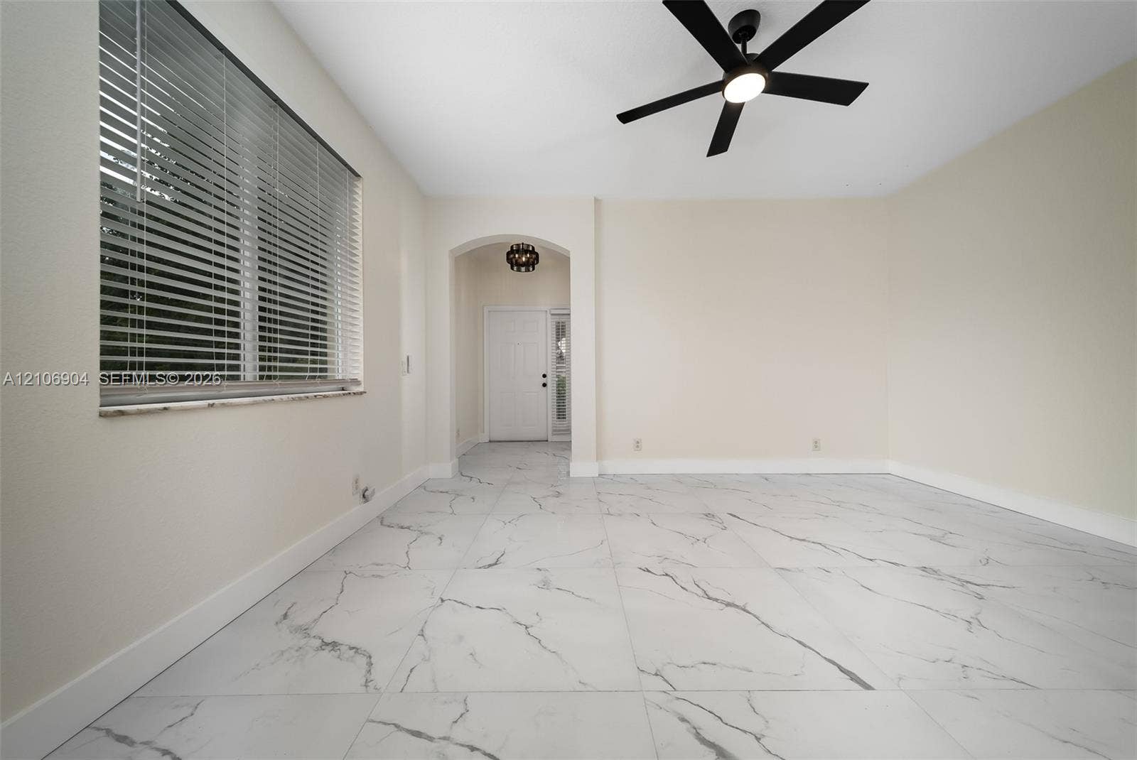 297 Conservation Drive, Weston, FL 33327 Large-format tile flooring, arched entryway, matte black ceiling fan, and window with built-in blinds