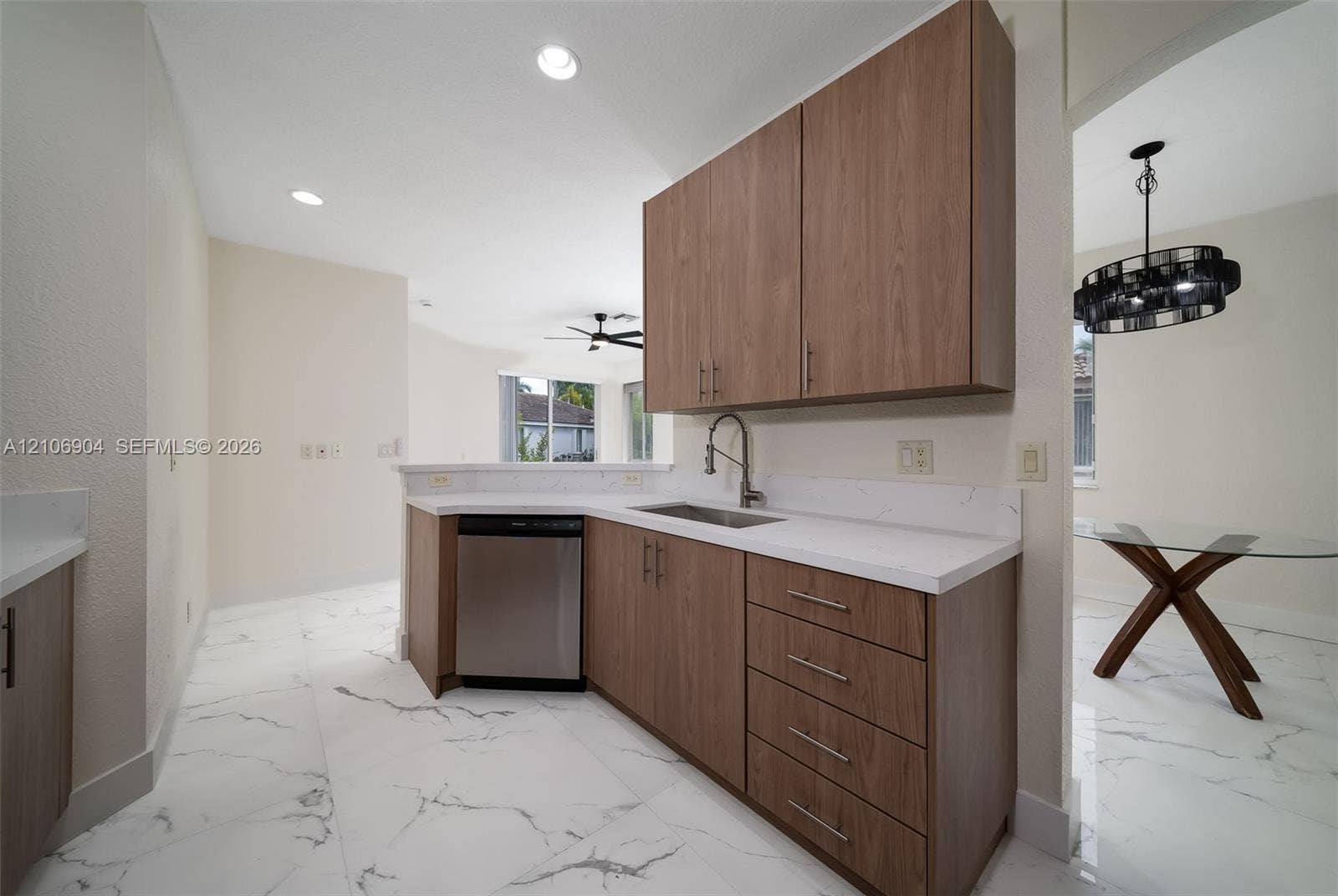 297 Conservation Drive, Weston, FL 33327 Kitchen featuring wood-finish cabinetry, white stone-patterned countertops, recessed lighting, and large-format porcelain tile flooring