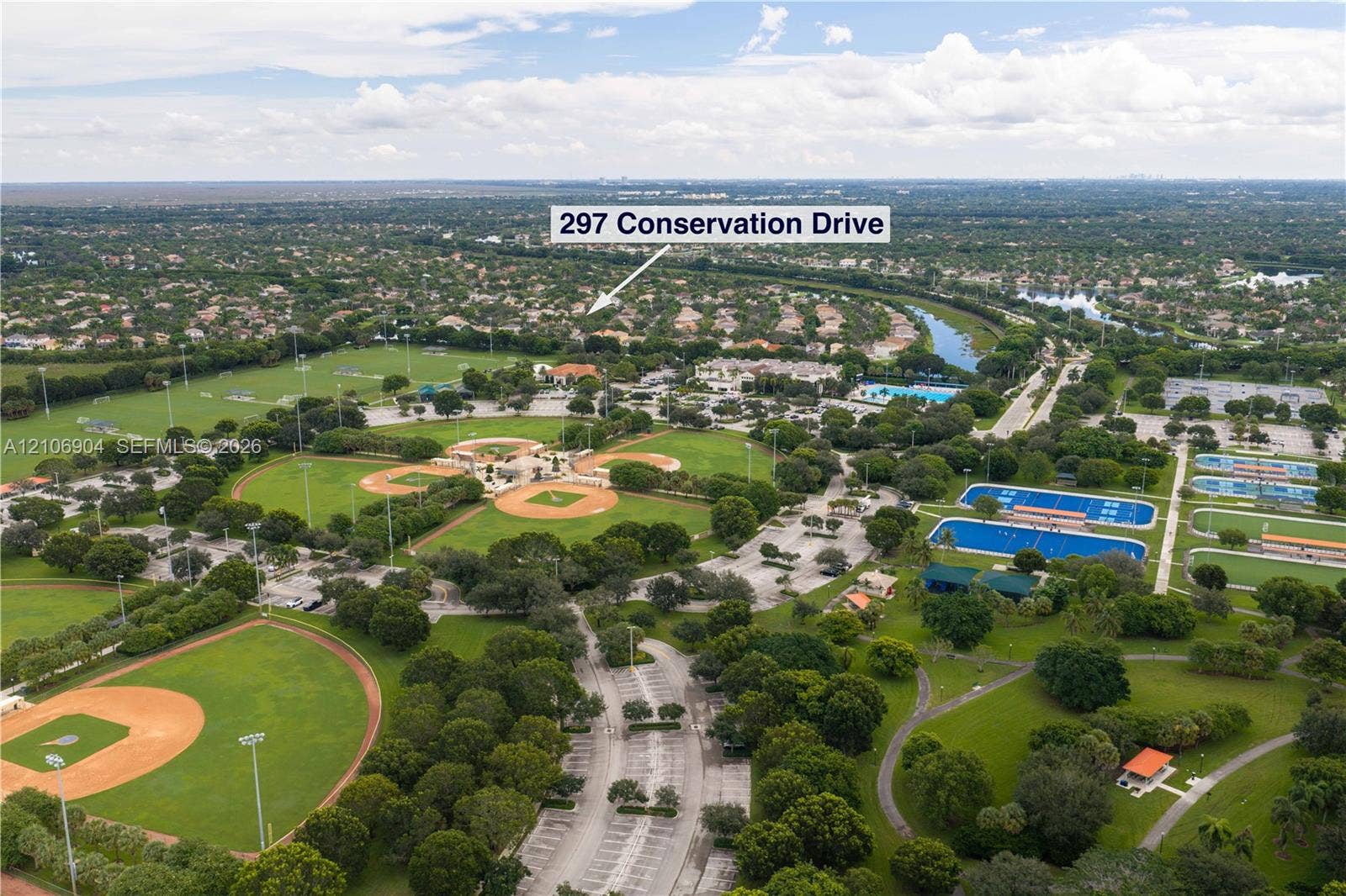 297 Conservation Drive, Weston, FL 33327 Aerial perspective showcasing proximity to recreational grounds featuring multiple baseball diamonds, tennis courts, and expansive green space