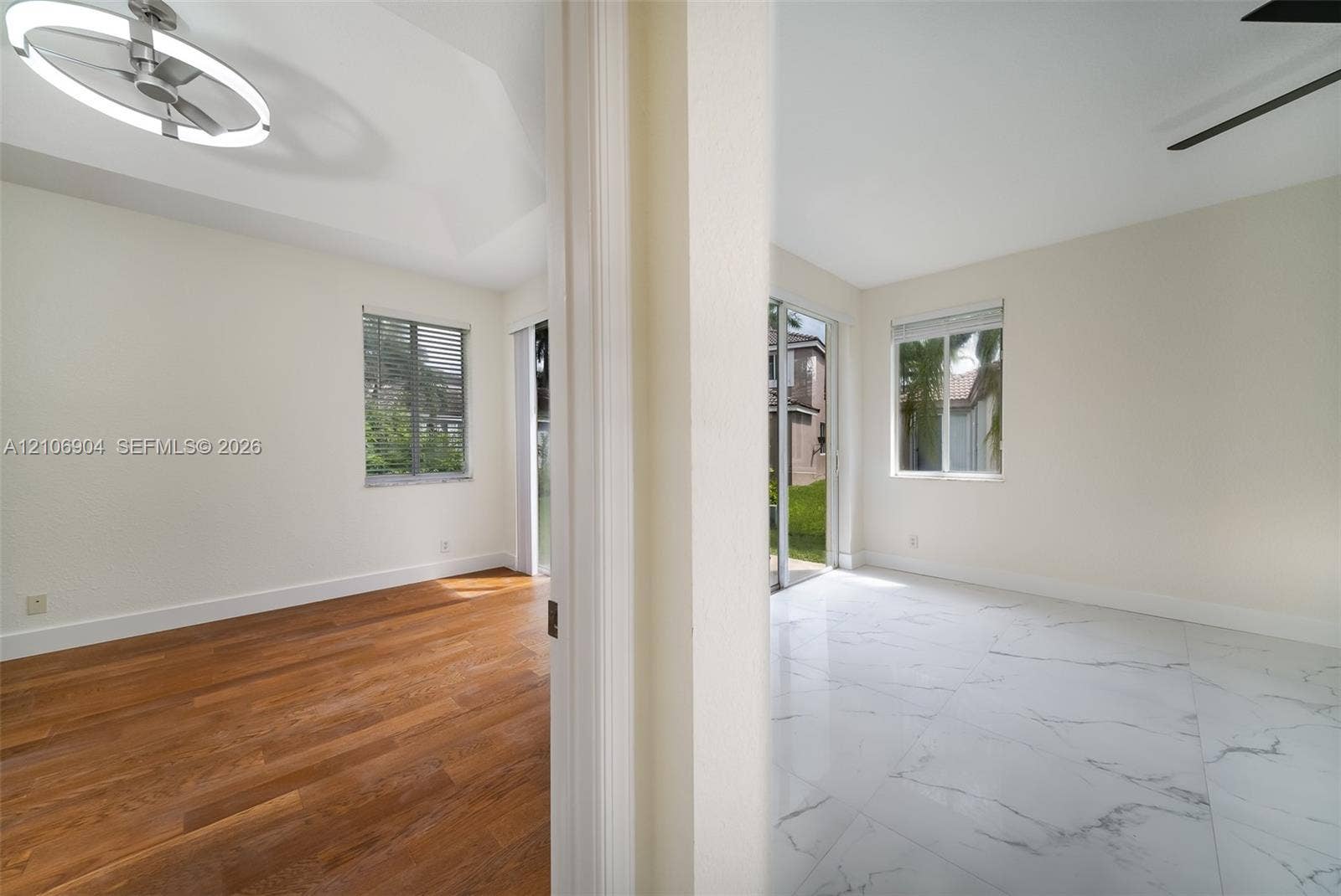 297 Conservation Drive, Weston, FL 33327 Interior space featuring vaulted ceilings, wood-finish flooring, large-format tile flooring, a contemporary circular LED chandelier, and sliding glass doors