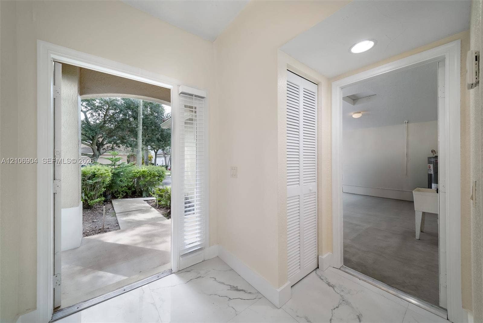 297 Conservation Drive, Weston, FL 33327 Entry featuring stone-finish tile flooring, white louvered closet doors, and recessed lighting