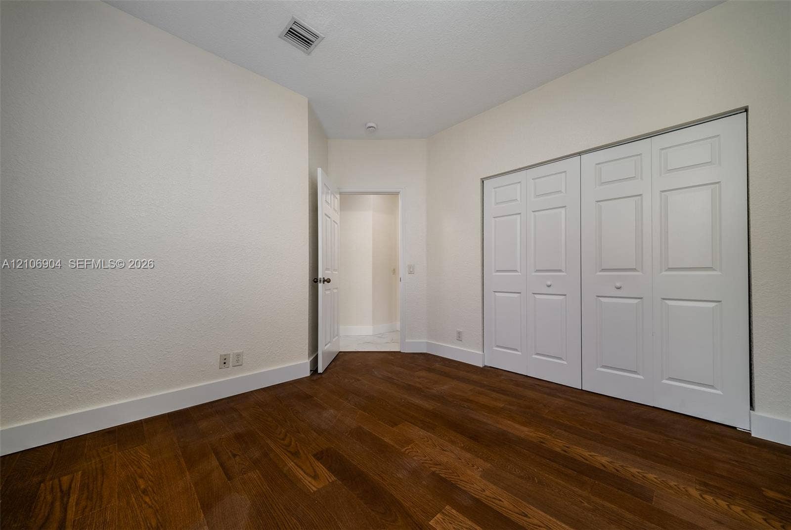 297 Conservation Drive, Weston, FL 33327 Wood-finish flooring, neutral wall tones, and built-in closet with six-panel doors