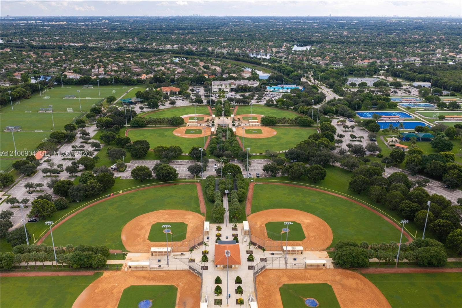 297 Conservation Drive, Weston, FL 33327 Aerial perspective of a large-scale recreational complex featuring multiple baseball diamonds, manicured grass fields, paved parking areas, and mature landscaping