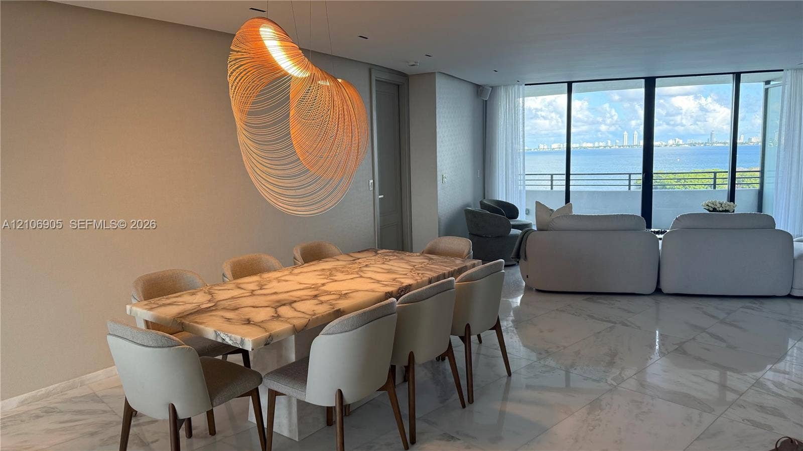 720 NE 69th Street, #10N, Miami, FL 33138 Polished stone flooring, custom sculptural light fixture, and floor-to-ceiling glass wall with access to an expansive balcony