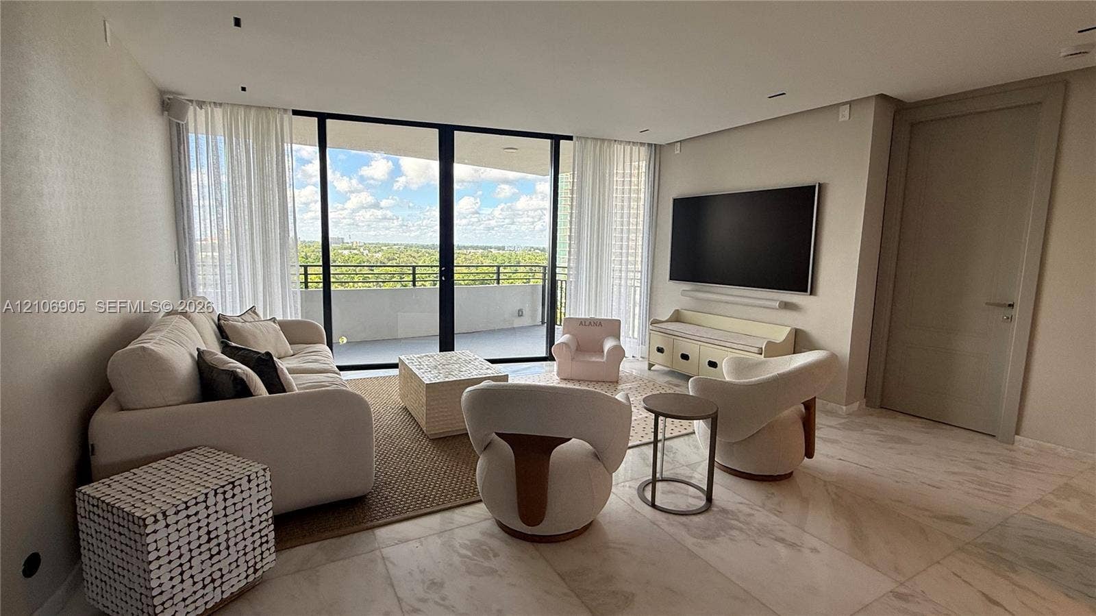 720 NE 69th Street, #10N, Miami, FL 33138 Living area featuring full-height glass sliding doors, stone tile flooring, recessed ceiling lighting, and a neutral color palette