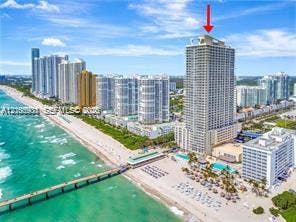 High-rise tower featuring a tiered architectural design, proximity to the coastline, and extensive multi-level outdoor pool areas