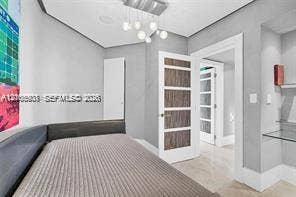 Contemporary interior featuring a multi-light globe chandelier, wood-grain panel doors, glass-paneled interior doors, built-in glass shelving, and neutral-toned flooring