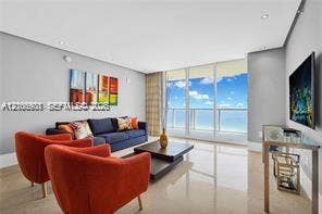 Floor-to-ceiling glass windows, polished tile flooring, recessed ceiling lighting, and neutral wall tones