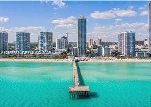 Aerial perspective of Atlantic coastline featuring turquoise ocean waters and a prominent concrete fishing pier