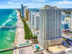 High-rise building situated on the coastline featuring direct beach access, an outdoor swimming pool, and proximity to the Atlantic Ocean