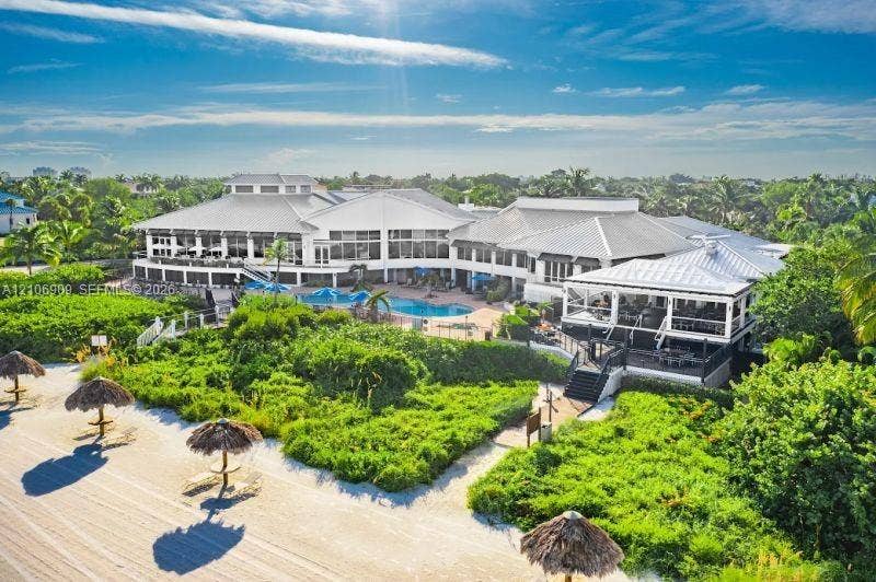 331 Wild Orchid Lane, Marco Island, Marco Island, FL 34145 Beachfront estate featuring direct coastal access, an expansive swimming pool, multi-level covered terraces, and mature lush landscaping