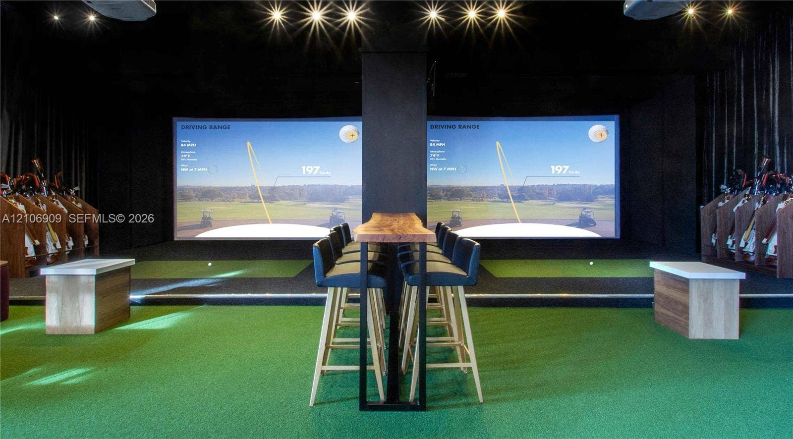 331 Wild Orchid Lane, Marco Island, Marco Island, FL 34145 Indoor golf simulator room featuring dual projection screens, high-impact turf flooring, recessed ceiling lighting, and built-in wood cabinetry