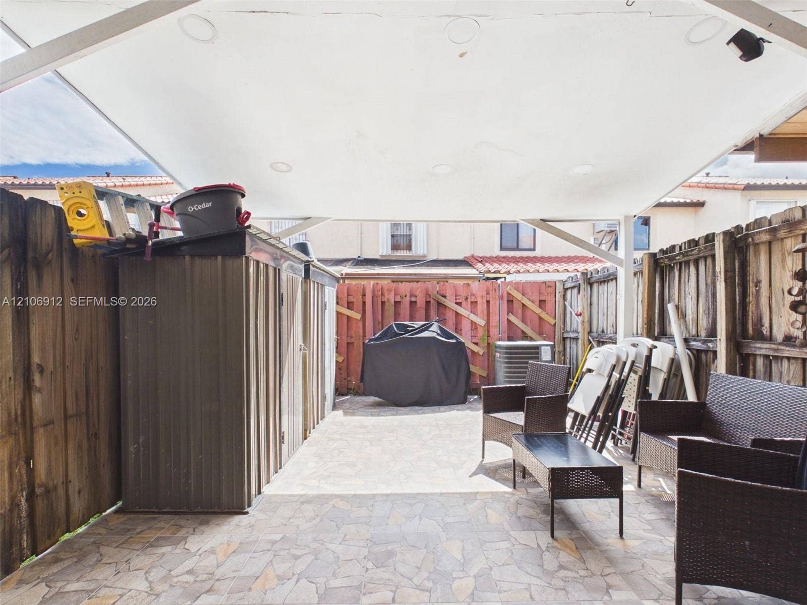 1142 W 42nd Street, #19, Hialeah, FL 33012 Covered patio featuring stone-tiled flooring, integrated recessed lighting, and enclosed wood fencing