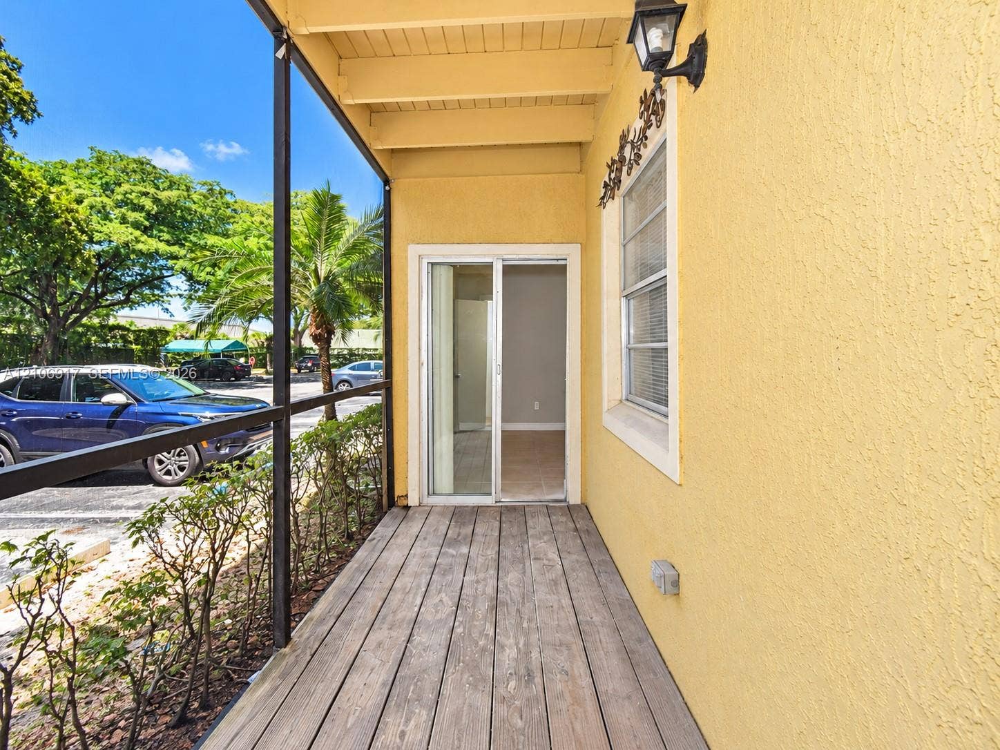 Screened-in porch featuring wood-plank flooring, stucco exterior wall, and sliding glass entry door