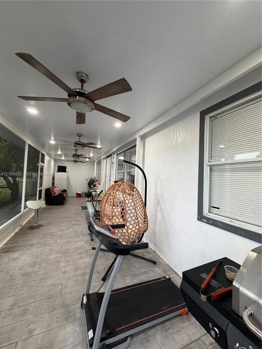 19800 SW 180 Avenue, #t, Miami, FL 33187 Enclosed porch featuring wood-finish tile flooring, recessed lighting, and multiple ceiling fans