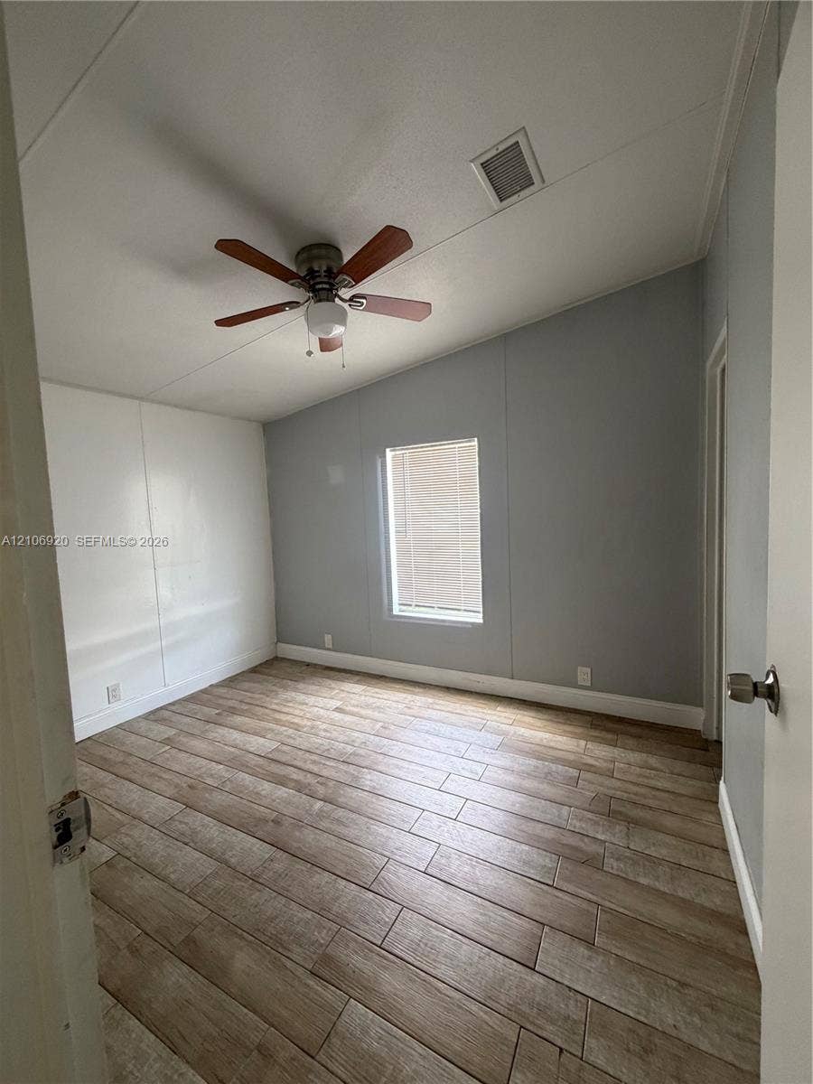 19800 SW 180 Avenue, #t, Miami, FL 33187 Room featuring vaulted ceilings, wood-finish flooring, and a ceiling fan with integrated lighting