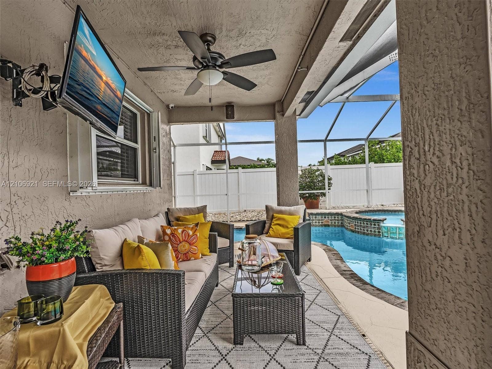 Covered lanai featuring a ceiling fan, recessed lighting, and a screened-in enclosure with an inground pool and spa