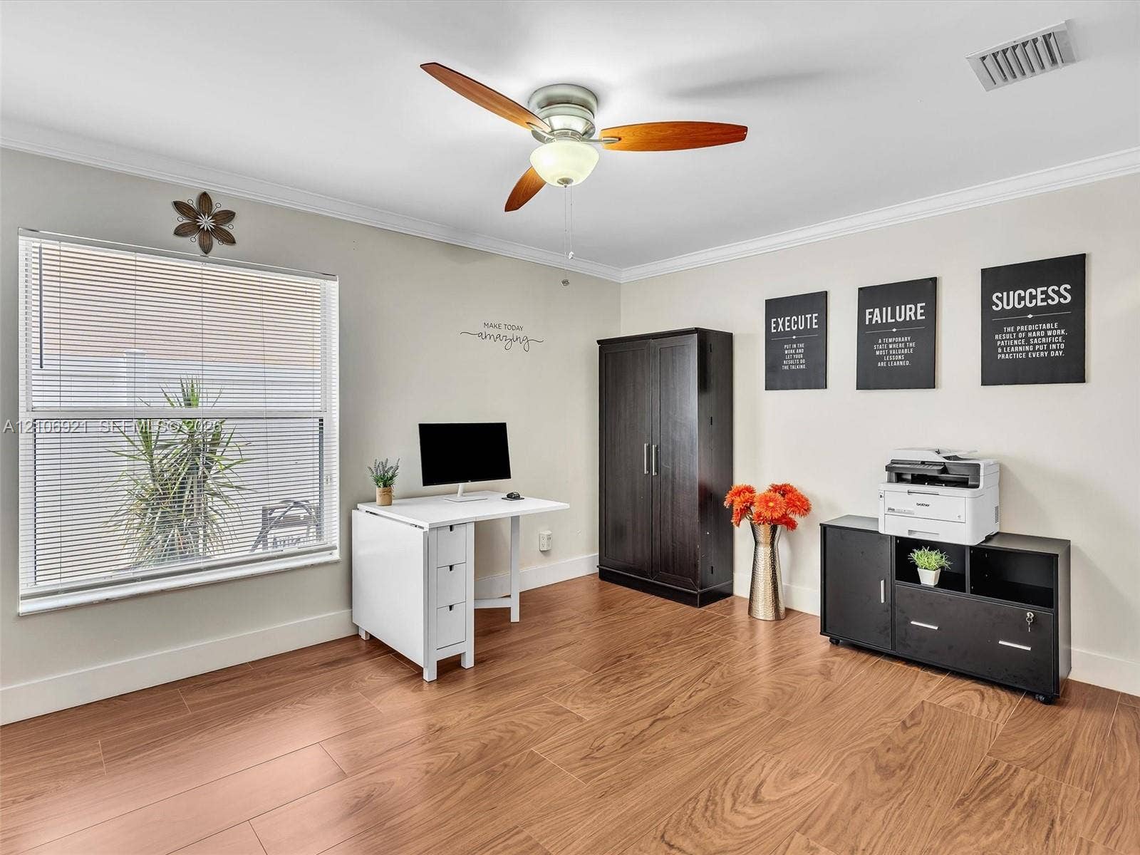 Room featuring wood-finish flooring, crown molding, and a ceiling fan with integrated light fixture