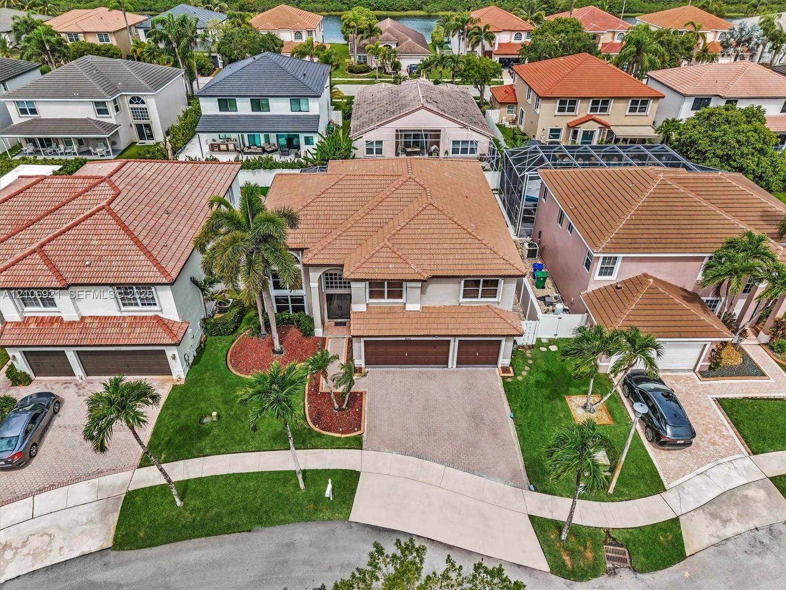 Two-story residence featuring a tile roof, an integrated three-car garage, and a concrete driveway
