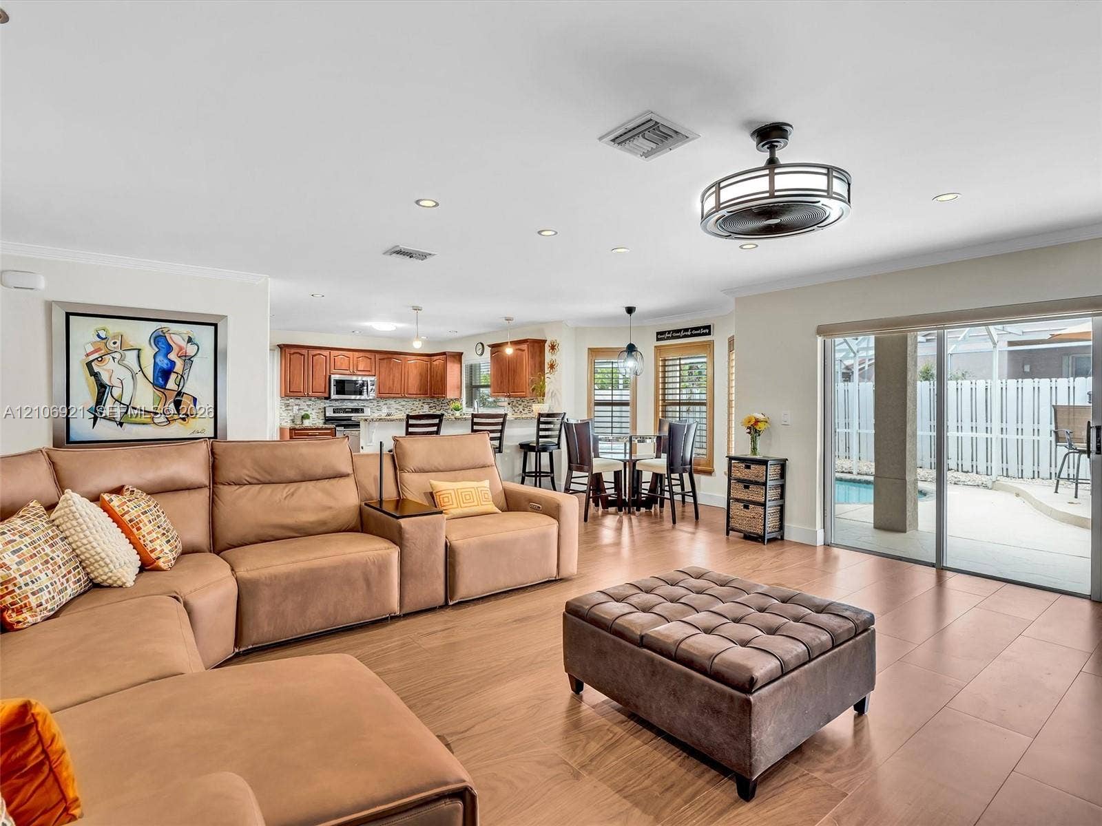 Open-concept interior featuring wood-finish flooring, recessed lighting, a modern ceiling fan, and sliding glass doors with exterior access