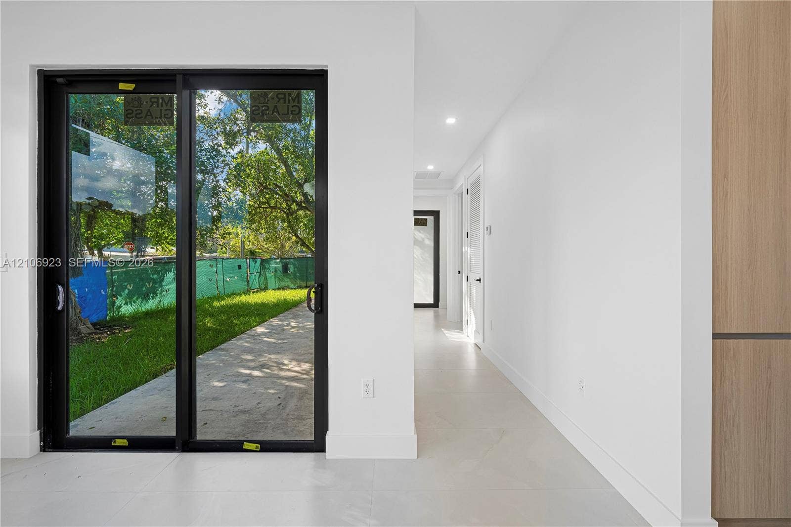 870 Superior Street, Opa Locka, FL 33054 Black-framed sliding glass doors, neutral tile flooring, recessed ceiling lighting, and wood-finish cabinetry