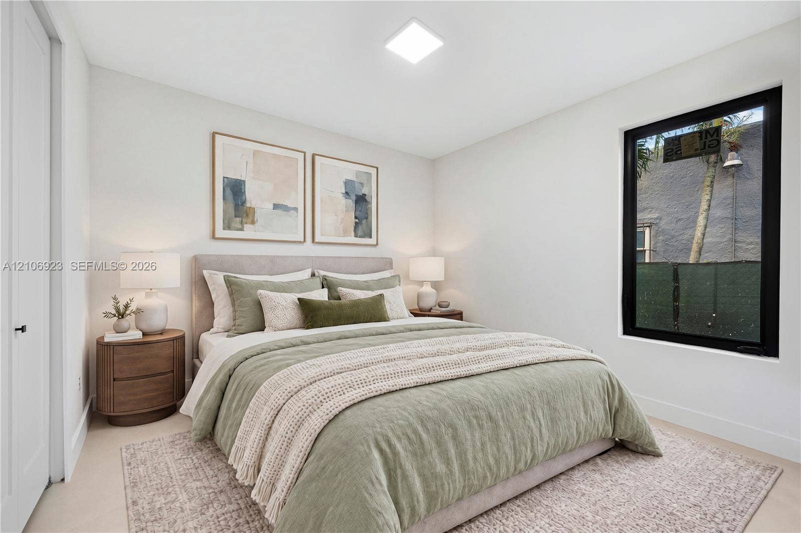 870 Superior Street, Opa Locka, FL 33054 Neutral wall palette featuring high-contrast black window framing, clean-lined recessed lighting, and soft-toned wall-to-wall carpeting