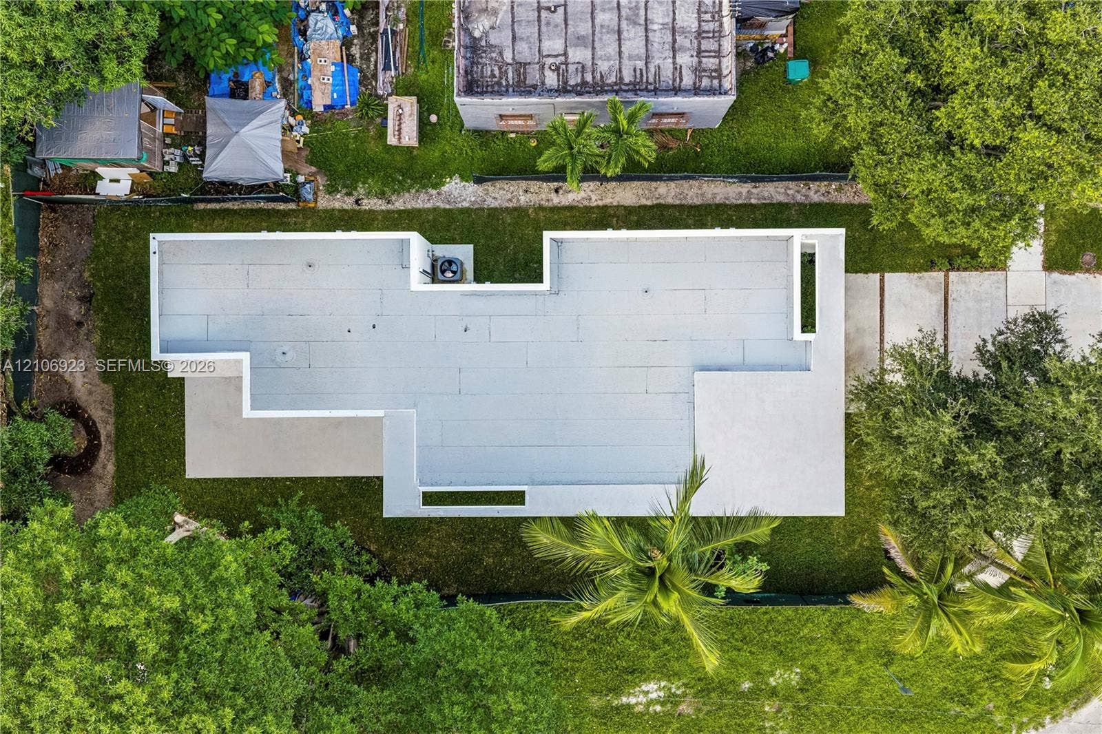 870 Superior Street, Opa Locka, FL 33054 Aerial perspective of property featuring a flat roofline, concrete driveway, and established trees within the lot boundaries