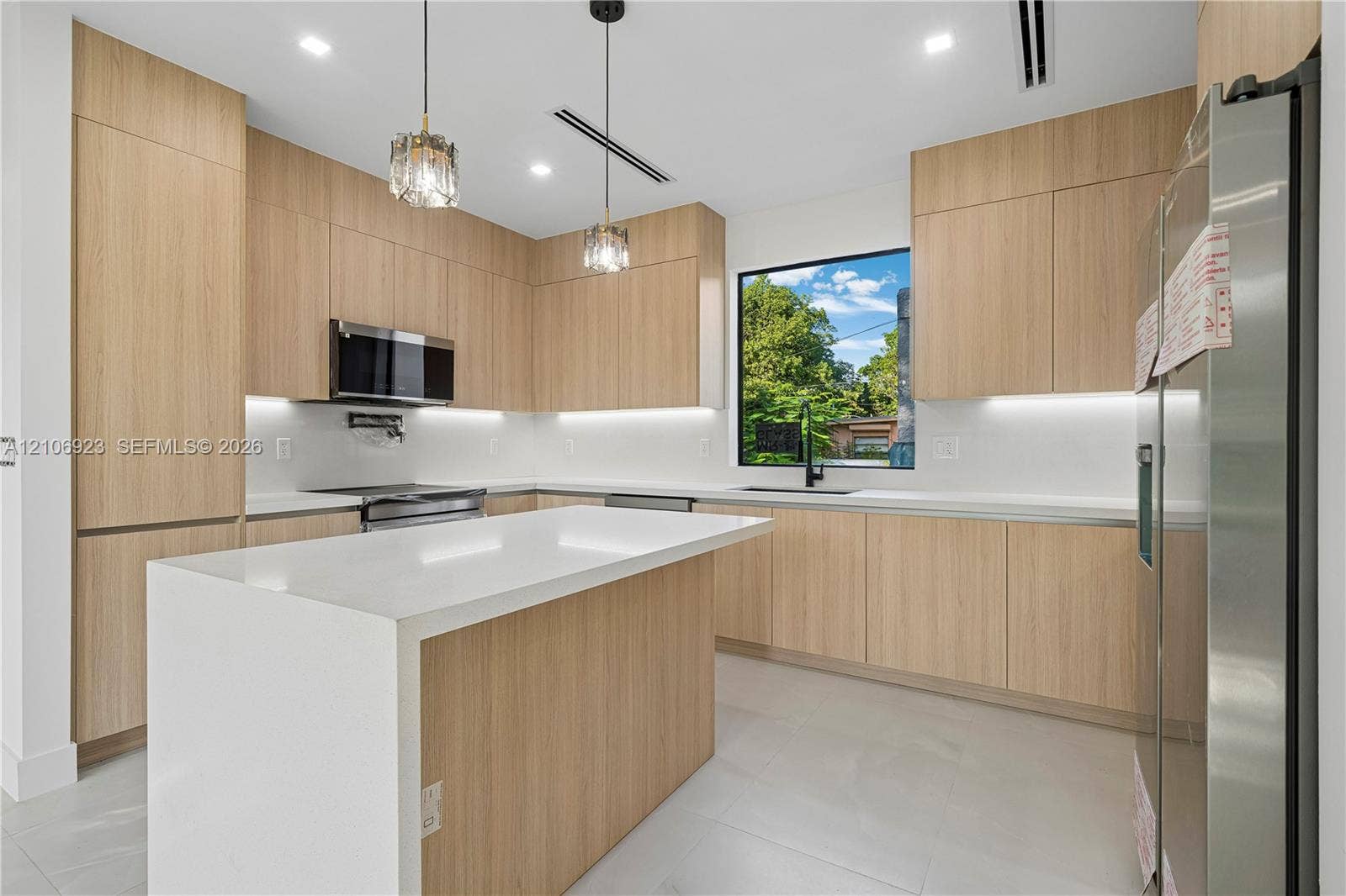 870 Superior Street, Opa Locka, FL 33054 Kitchen featuring flat-panel wood-finish cabinetry, a waterfall-edge island, white countertops, recessed lighting, and stainless steel appliances
