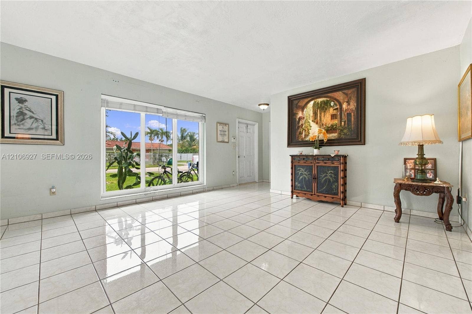 Interior space featuring large-format ceramic tile flooring, neutral wall tones, and a substantial picture window