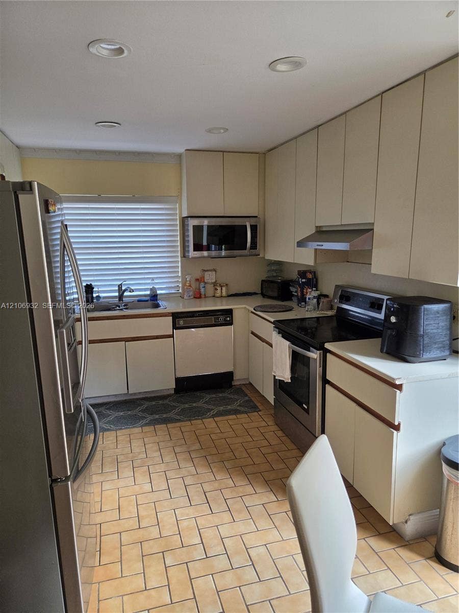 6328 NW 181st Terrace, Hialeah, FL 33015 Kitchen featuring flat-panel cabinetry, stainless steel appliances, recessed ceiling lighting, and ceramic tile flooring in a herringbone pattern