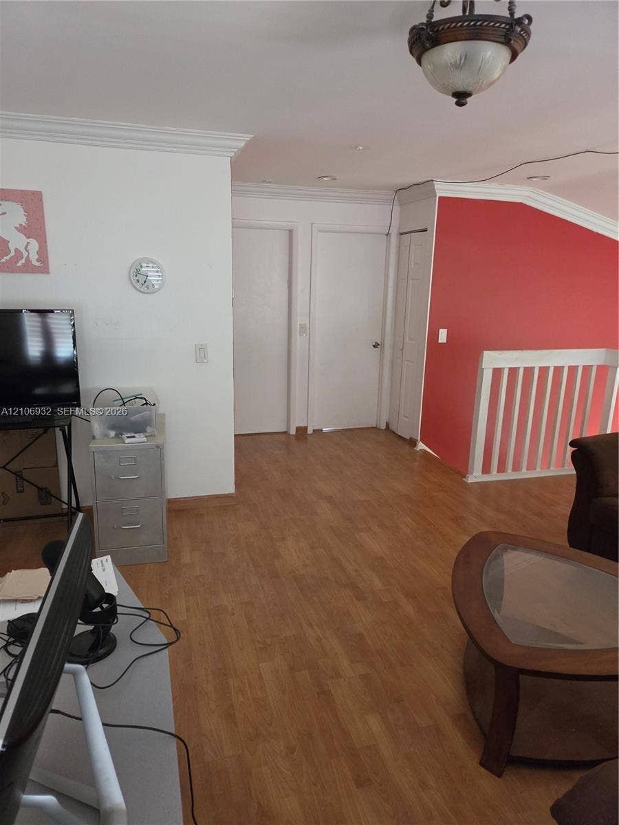6328 NW 181st Terrace, Hialeah, FL 33015 Wood-finish flooring, crown molding, semi-flush mount lighting, and white wooden stair railings