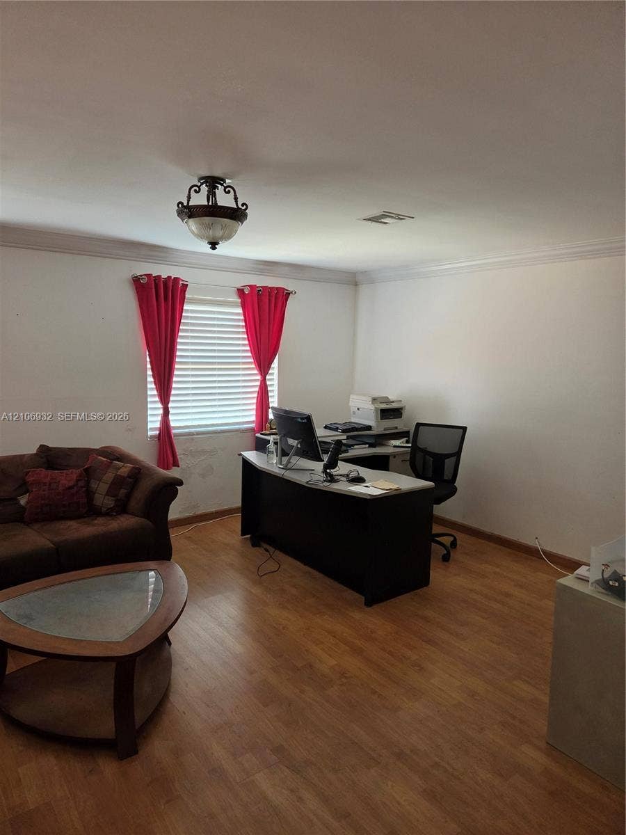 6328 NW 181st Terrace, Hialeah, FL 33015 Wood-finish flooring, crown molding, and a semi-flush mount light fixture
