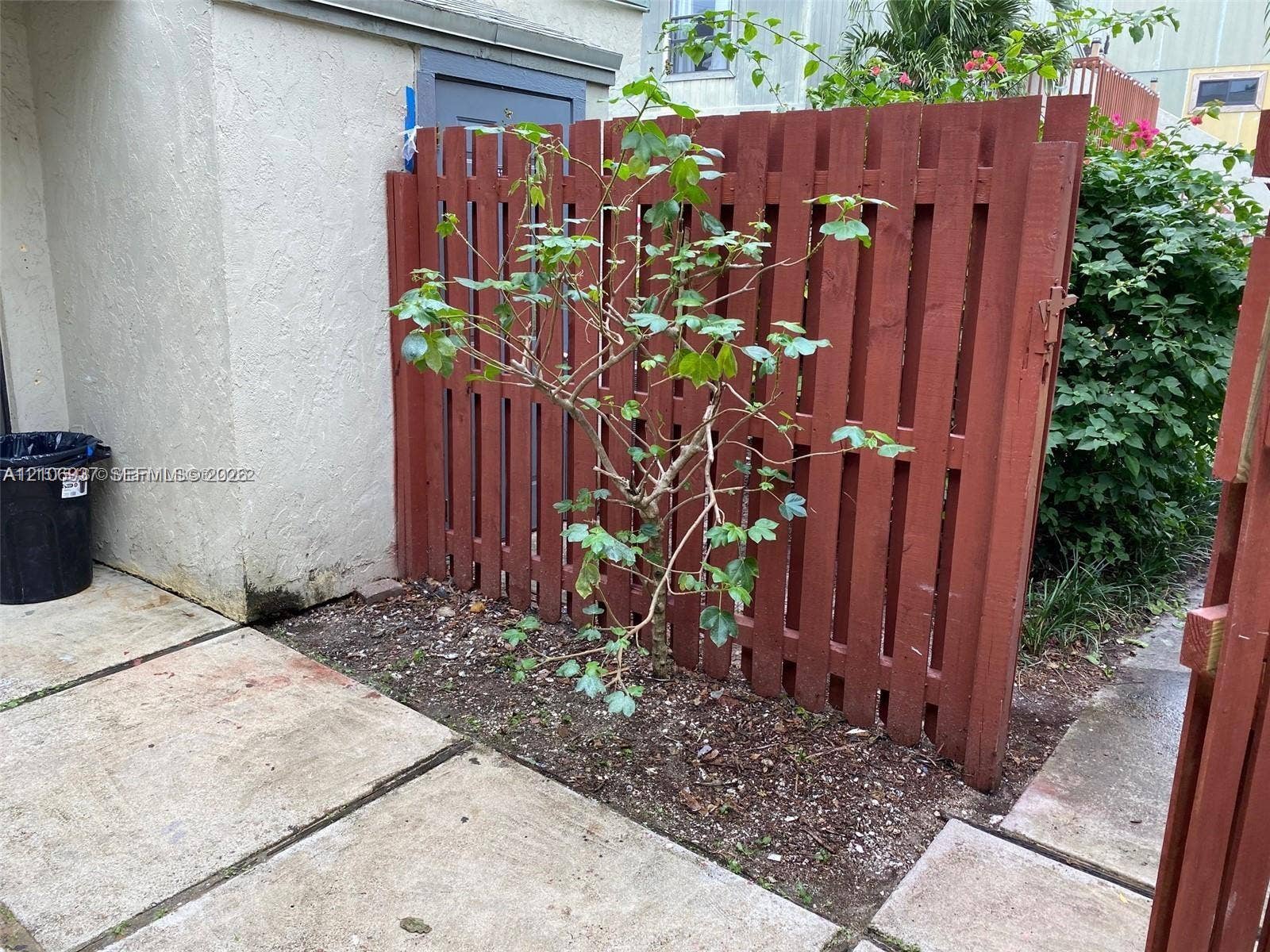 Exterior area featuring concrete pavers and a vertical slat wood-finish fence