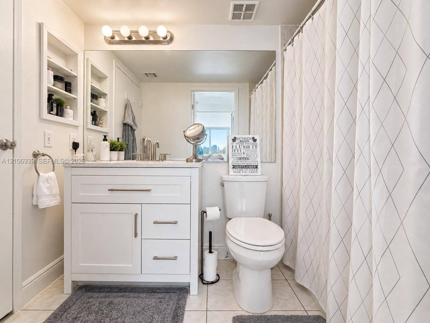 7601 E Treasure Drive, #802, North Bay Village, North Bay Village, FL 33141 Bathroom featuring a white vanity cabinet with stone countertop, undermount sink, brushed nickel hardware, and built-in recessed wall shelving