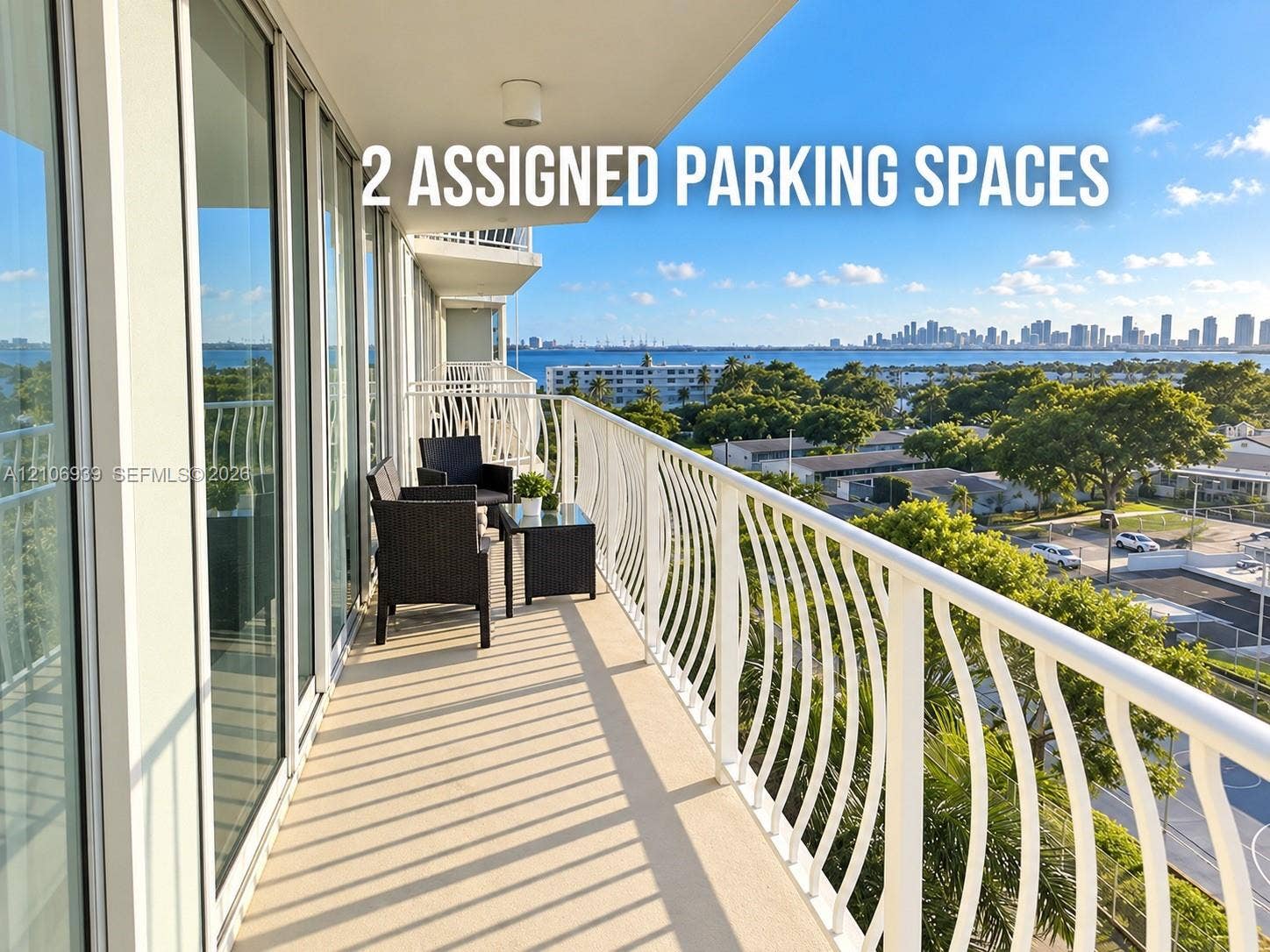 7601 E Treasure Drive, #802, North Bay Village, North Bay Village, FL 33141 Covered balcony featuring a white metal railing, floor-to-ceiling glass sliding doors, and water-fronting scenery