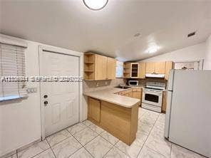 1674 NE 174th Street, #Rear, North Miami Beach, North Miami Beach, FL 33162 Kitchen featuring light wood-finish cabinetry, a peninsula counter, white appliances, and tiled flooring