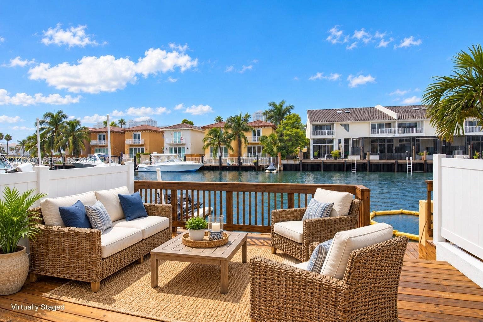Waterfront deck featuring wood-finish decking, horizontal wood balustrade railing, and privacy fencing