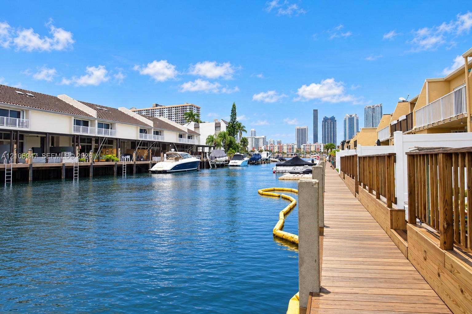 Waterfront property featuring a private wooden dock, direct canal access, and balcony railings